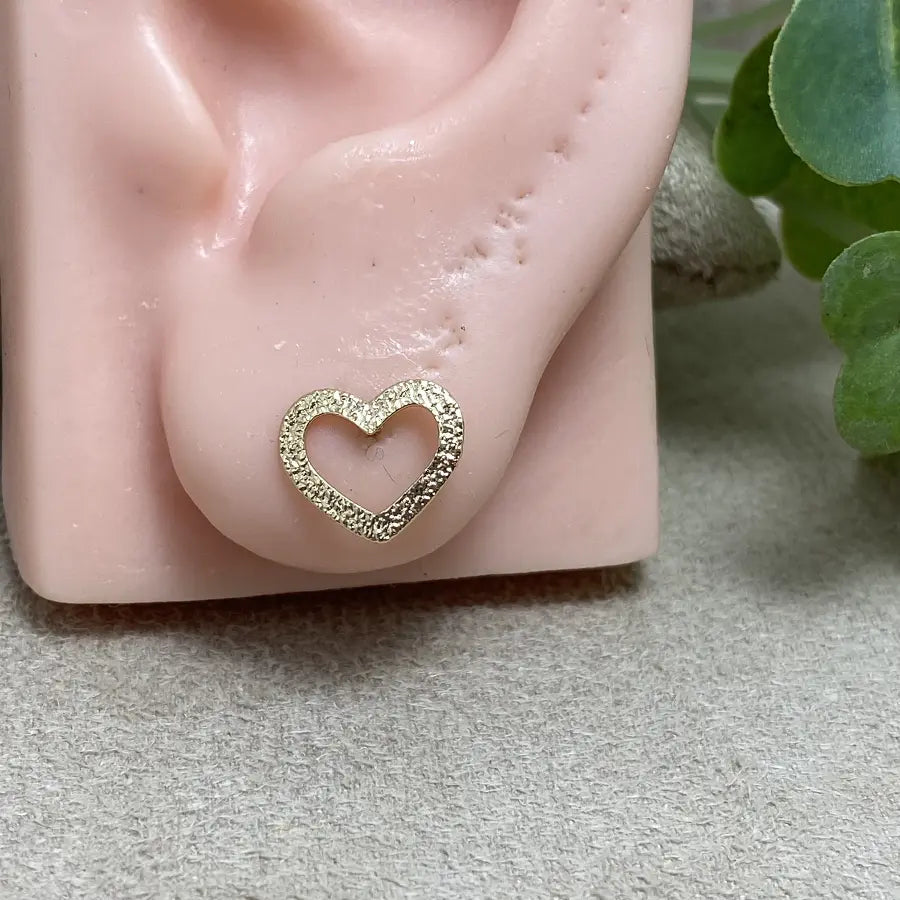 Gold-tone hollow heart earrings with a shiny texture.