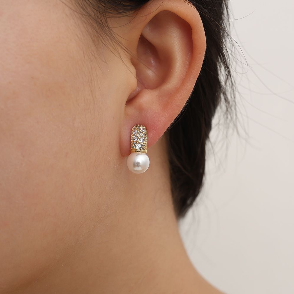 Gold earrings with pearl and sparkling cubic zirconia detail.
