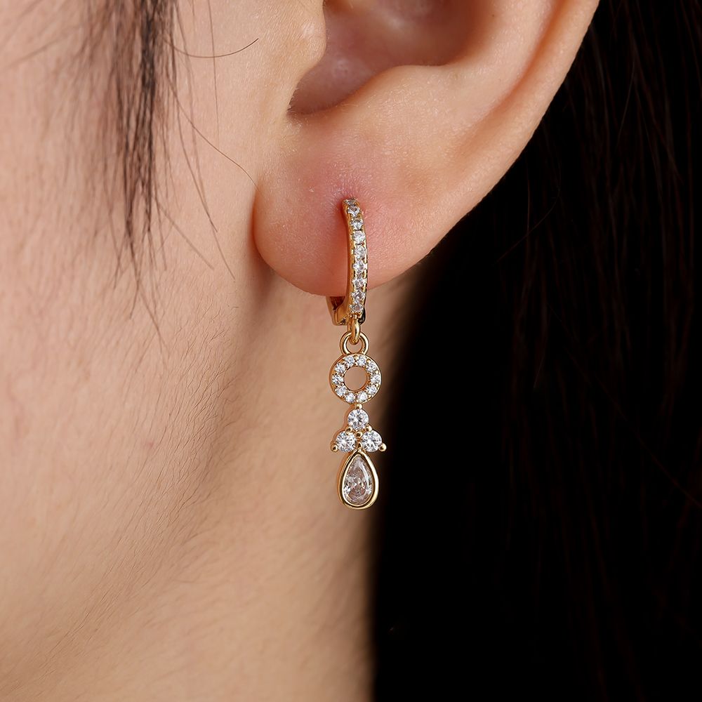 Gold earrings with circular pendants and a zirconia teardrop.