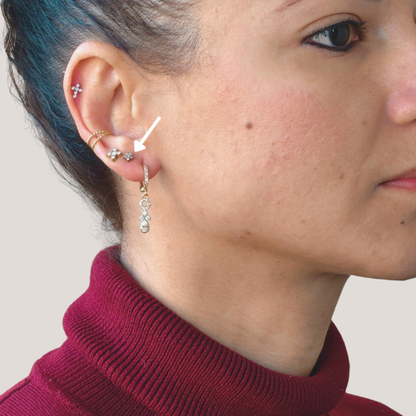 Ear piercing plated in a flower shape with cubic zirconia.