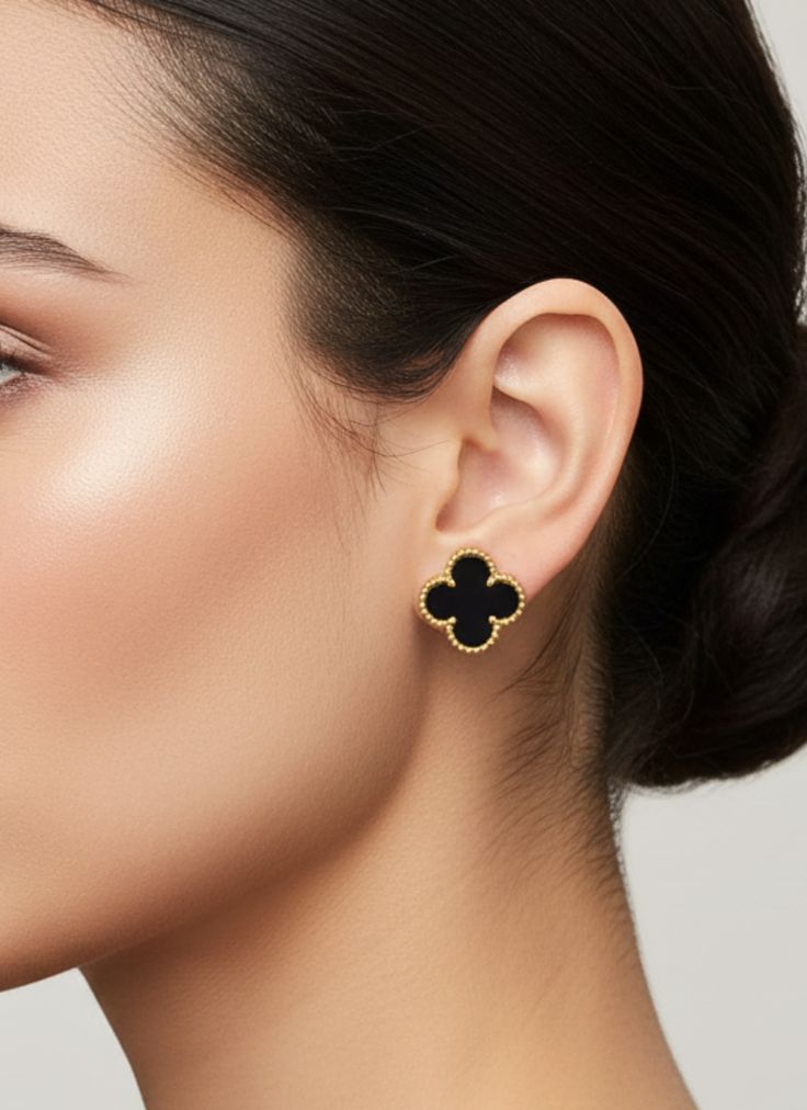 Gold-tone steel earrings with a black clover.
