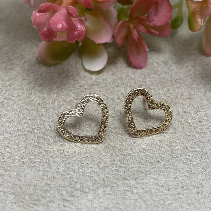 Gold-tone hollow heart earrings with a shiny texture.